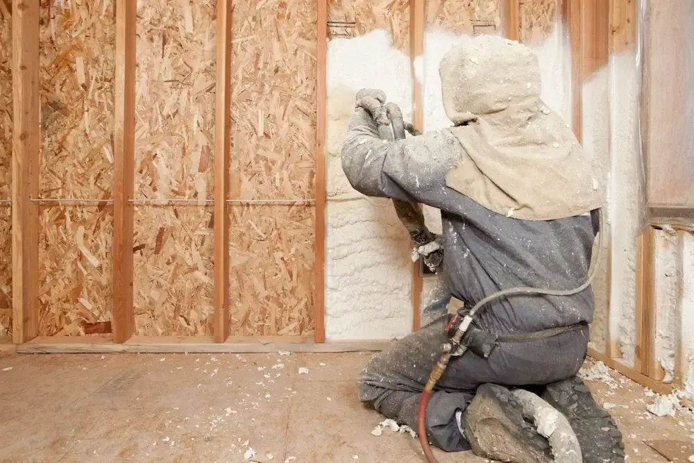 Worker installing spray foam insulation